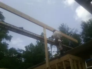 Carpenter setting a ridge beam over a new addition frame — Ice Dam Removal by Roofing Brothers in Potts Camp