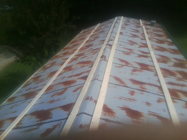 Rusted metal roof panels with new wood purlins before replacement — Storm Damage Roof Repair in Potts Camp by Roofing Brothers