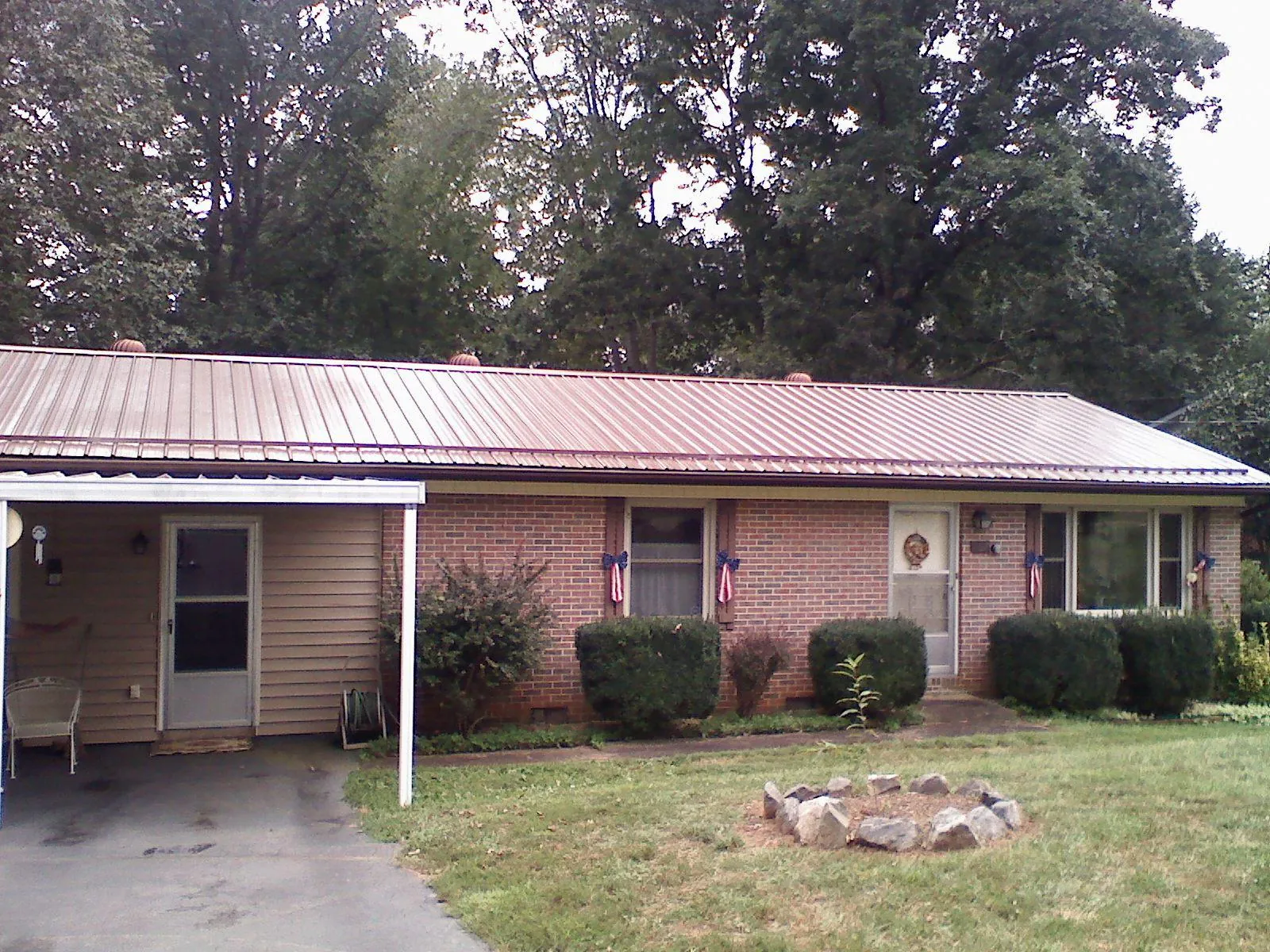 Bronze metal roof and carport on a brick ranch home — Roof Repair work by our crew in Potts Camp